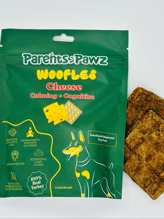 Green package of Pareths Pawz Whofles Cheese with two brown dog treats on a white background